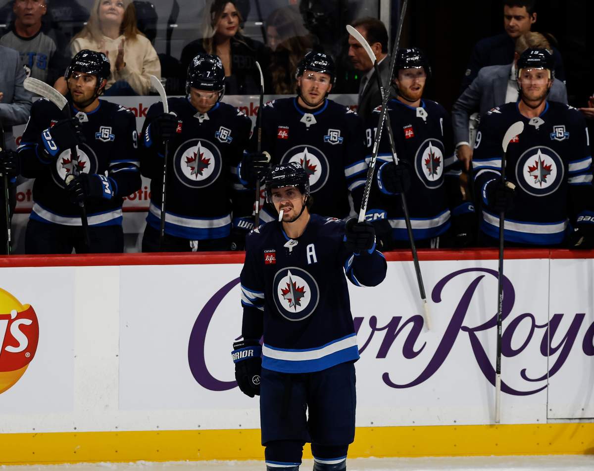 Winnipeg Jets' Mark Scheifele (55) raises his stick to the crowd as he is announced as franchise point leader during first period NHL action against the Nashville Predators in Winnipeg on Saturday, October 18, 2025. THE CANADIAN PRESS/John Woods.