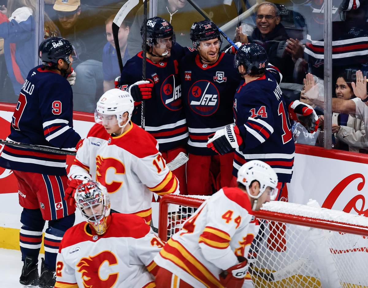 Winnipeg Jets' Alex Iafallo (9), Mark Scheifele (55), Gabriel Vilardi (13) and Gustav Nyquist (14) celebrate Vilardi's goal against the Calgary Flames during second period NHL action in Winnipeg on Friday, October 24, 2025. THE CANADIAN PRESS/John Woods.
