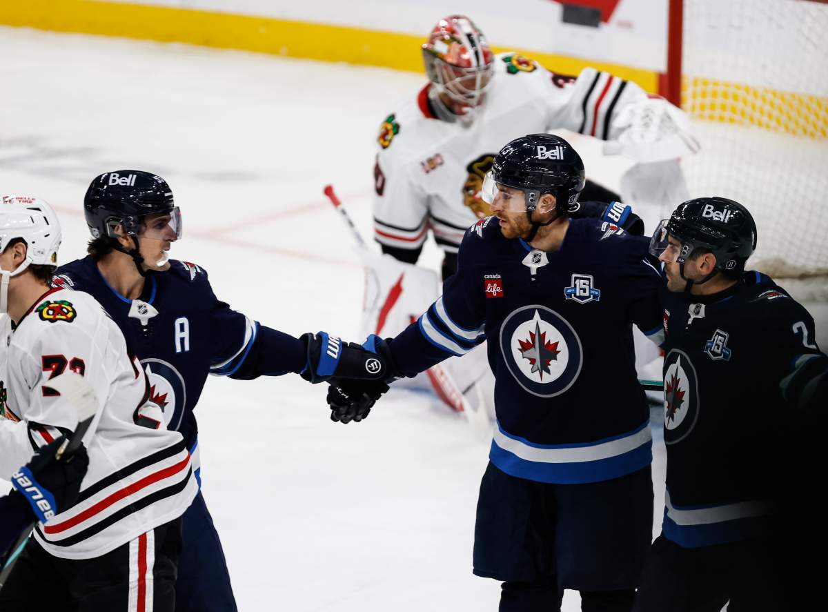 Winnipeg Jets' Mark Scheifele (55) and Dylan DeMelo (2) celebrate Gabriel Vilardi's (13) goal against the Chicago Blackhawks during second period NHL action in Winnipeg on Thursday, October 30, 2025. THE CANADIAN PRESS/John Woods.