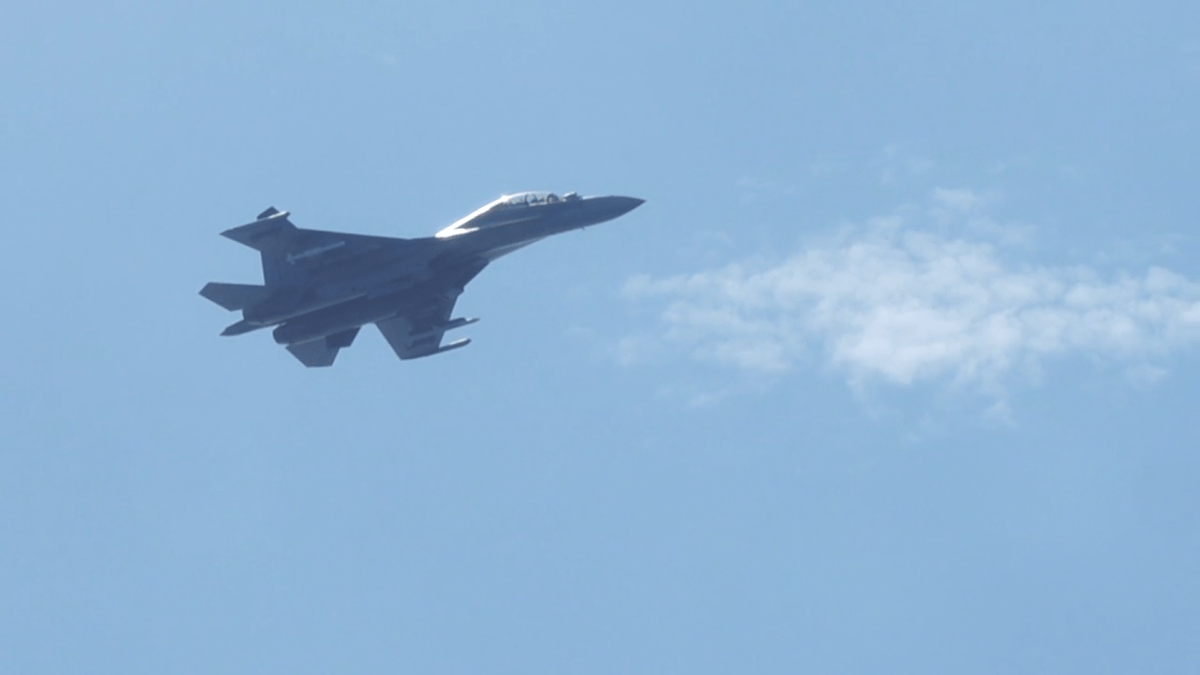 A fighter jet is seen in front of blue skies