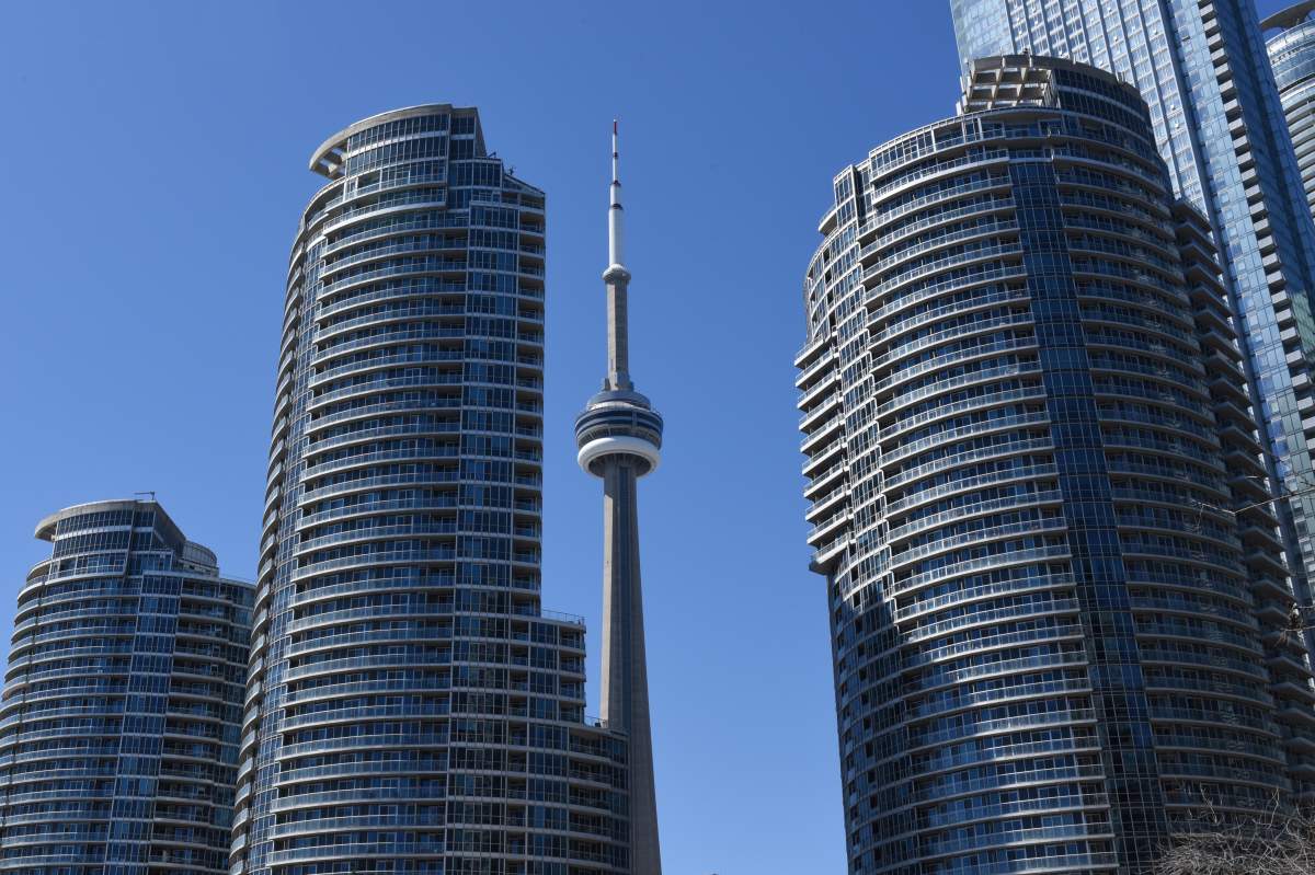 The CN Tower is pictured between the towers of the ICE Condominiums in Toronto, Ontario on April 25, 2024.