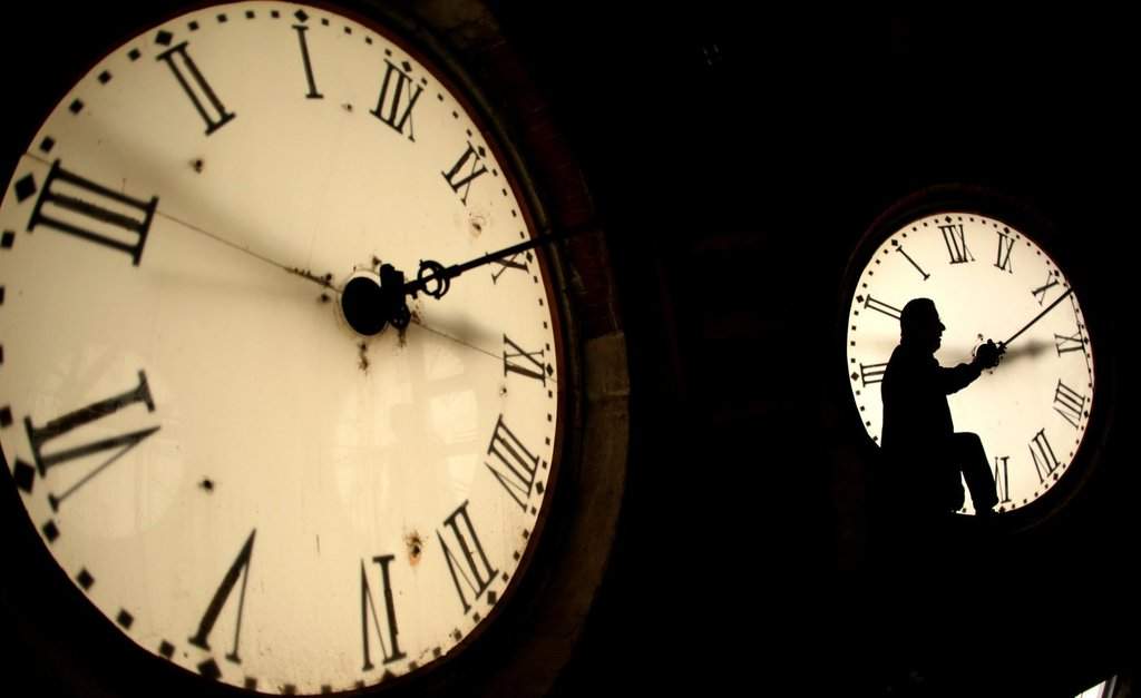 FILE - Custodian Ray Keen inspects a clock face before changing the time on the 100-year-old clock atop the Clay County Courthouse March 8, 2014, in Clay Center, Kan. (AP Photo/Charlie Riedel, File).