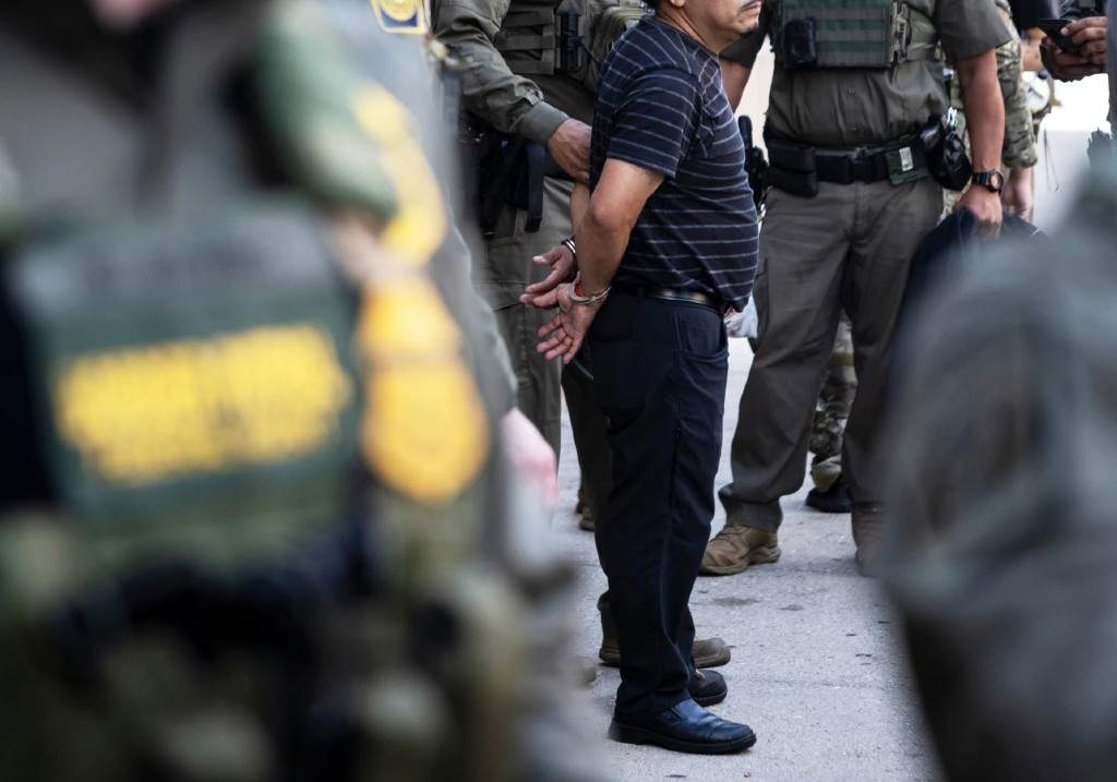 Federal immigration enforcement agents detain a man who took off running away from them as they were walking on North Clark Street near West Superior Street in the River North neighborhood, Sunday, Sept. 28, 2025, in Chicago.