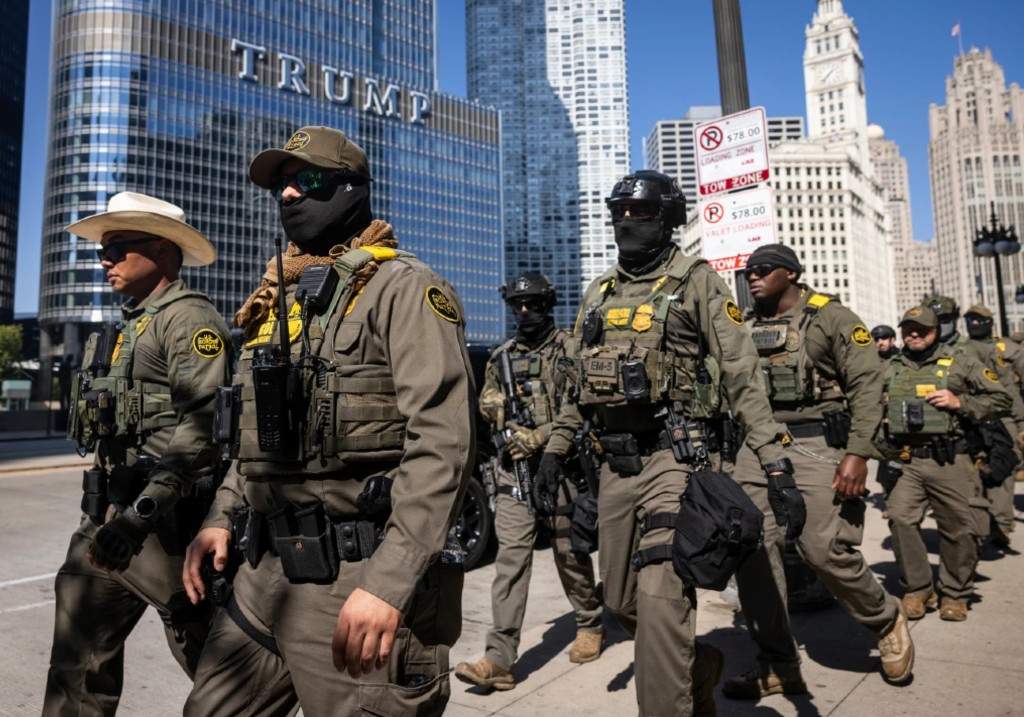 Federal agents from U.S. Immigration and Customs Enforcement and U.S. Customs and Border Protection walk along West Wacker Drive in the Loop, Sunday, Sept. 28, 2025, in Chicago.