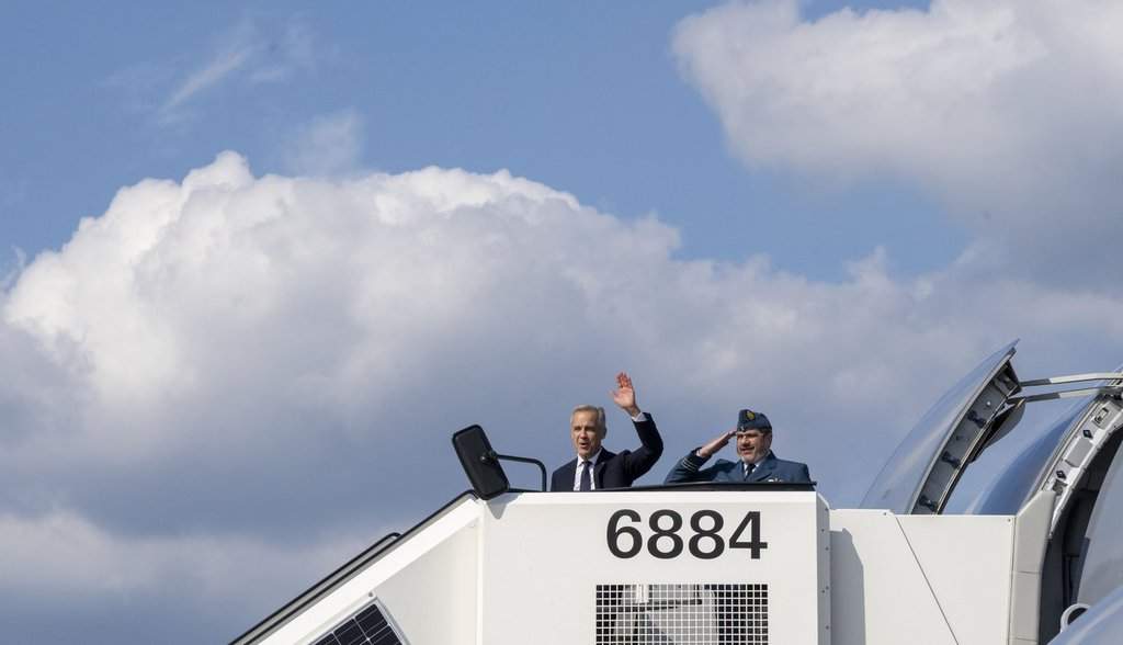Prime Minister Mark Carney waves as he boards the government plane heading to Riga, Latvia from the airport in Hamburg, Germany on Tuesday, Aug. 26, 2025. THE CANADIAN PRESS/Christinne Muschi.
