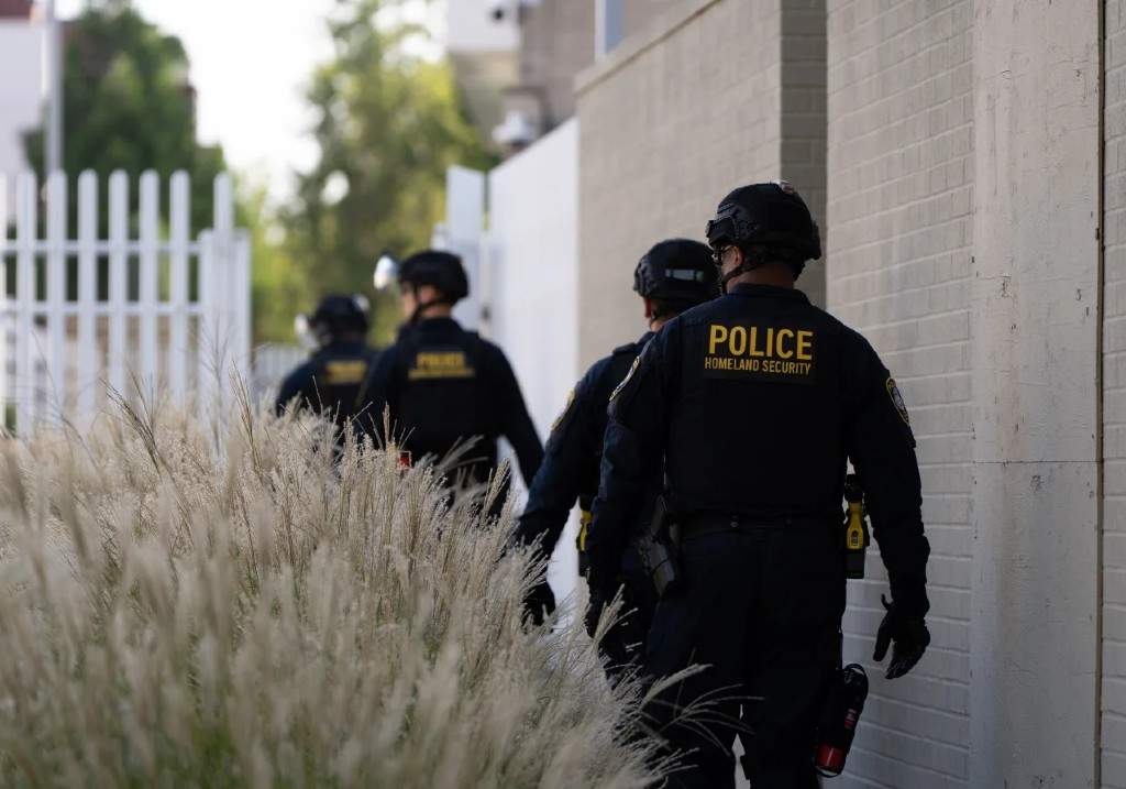 Department of Homeland Security officials walk to the gates of the U.S. Immigration and Customs Enforcement facility after inspecting an area outside on Sunday, Sept. 28, 2025, in Portland, Ore.