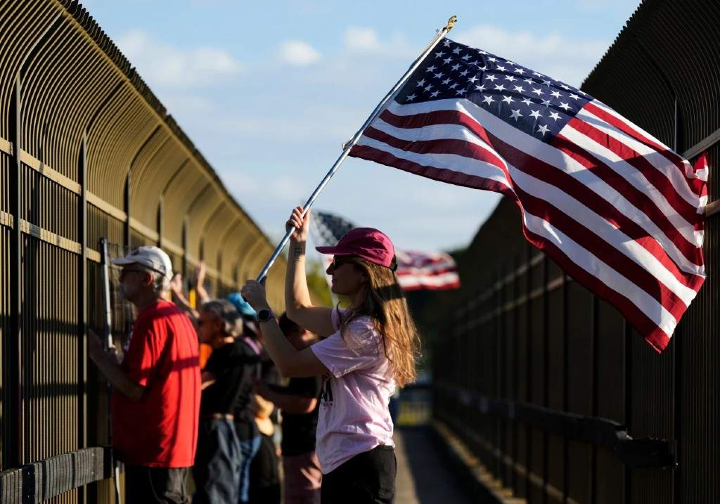Jeannie Fanning waves an American flag while demonstrating above Interstate 40 in Nashville, Tenn., Friday, Sept. 26, 2025, against the deployment of the National Guard in Memphis.
