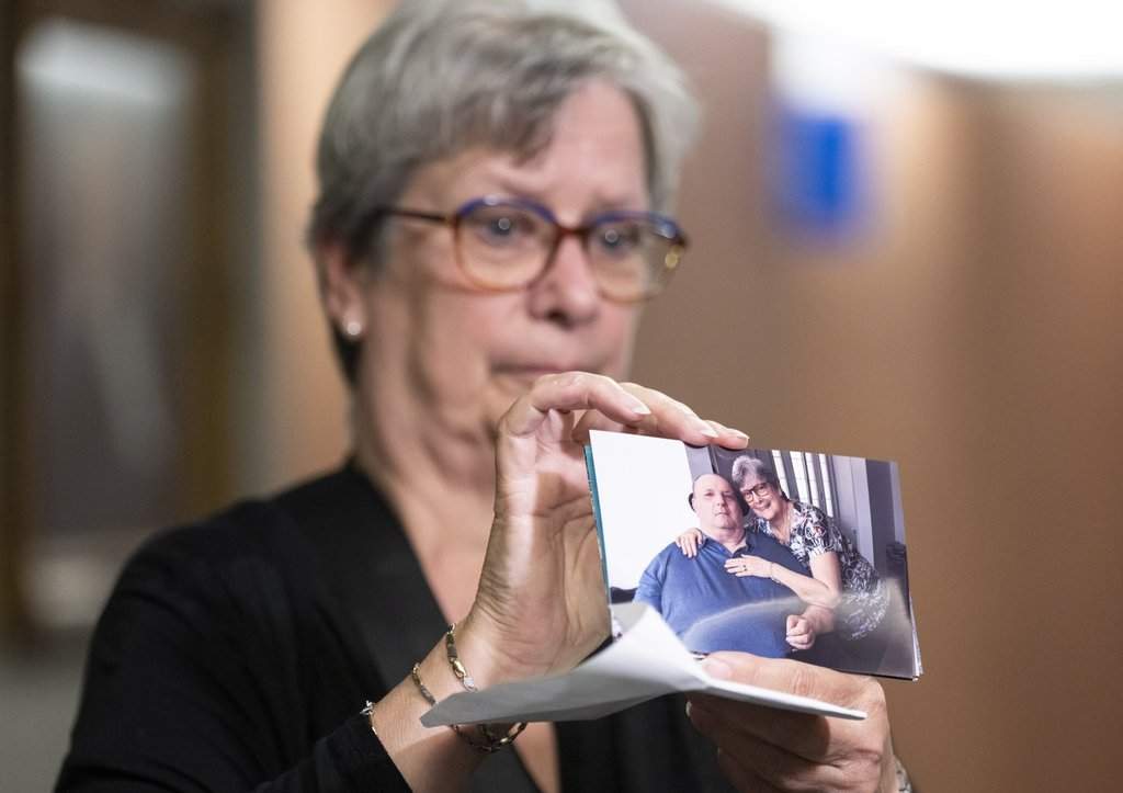 Sylvie Brosseau shows a photo of her herself with her husband at the courthouse in Montreal on Thursday, May 15, 2025. Brosseau’s late partner Normand Meunier requested medical assistance in dying last year after getting pressure sores during a stay in the St-Jerome hospital.