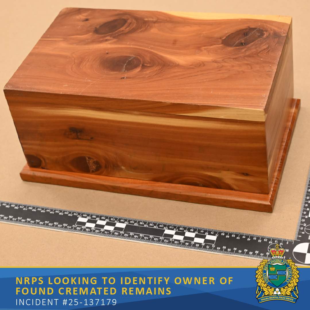 A wooden urn with visible knots and grain is pictured beside a measurement scale in a police evidence photo.