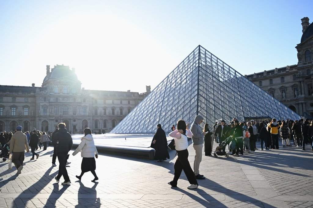 People wait for the opening of the Louvre museum, Thursday, Oct. 30, 2025 in Paris.