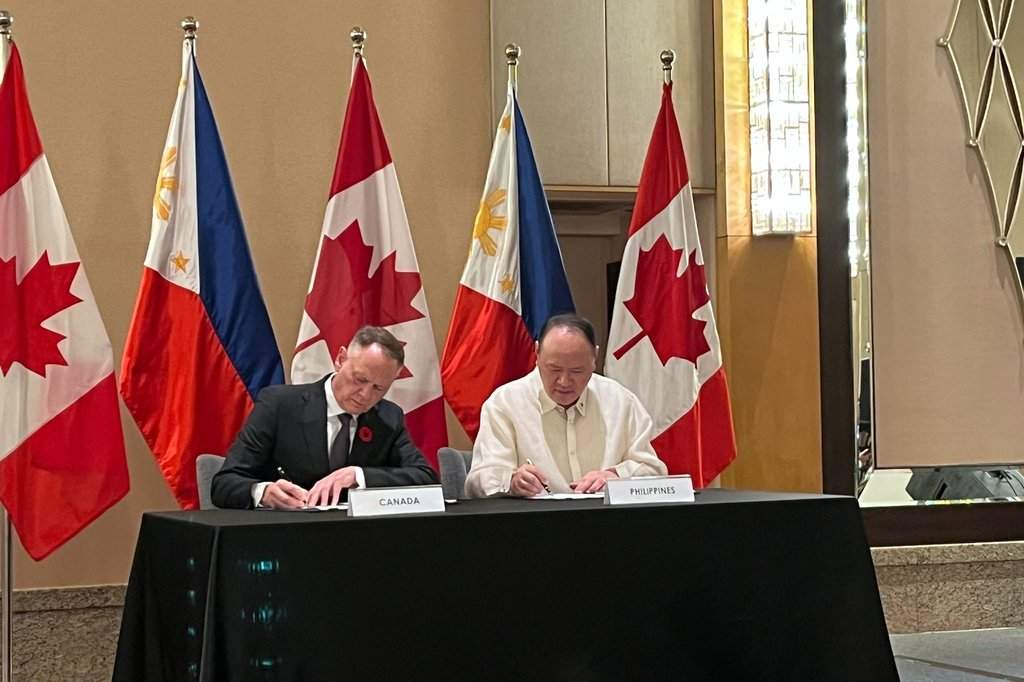 Canadian Defense Minister, David McGuinty and Philippine Defense Secretary Gilberto Teodoro Jr. sign an agreement in Manila, Sunday, Nov. 2, 2025. 
