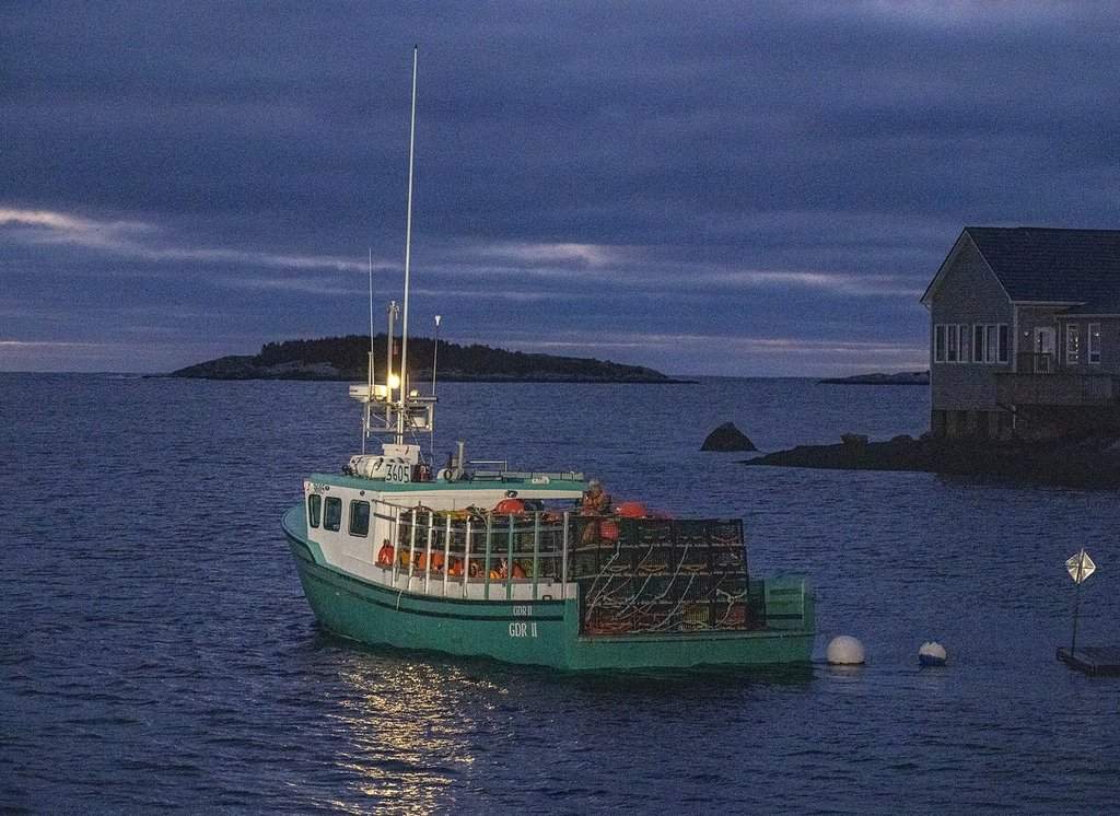 A lobster boat, loaded with pots and buoys, waits for the official start of the season in West Dover, N.S., on Nov. 29, 2022. THE CANADIAN PRESS/Andrew Vaughan.