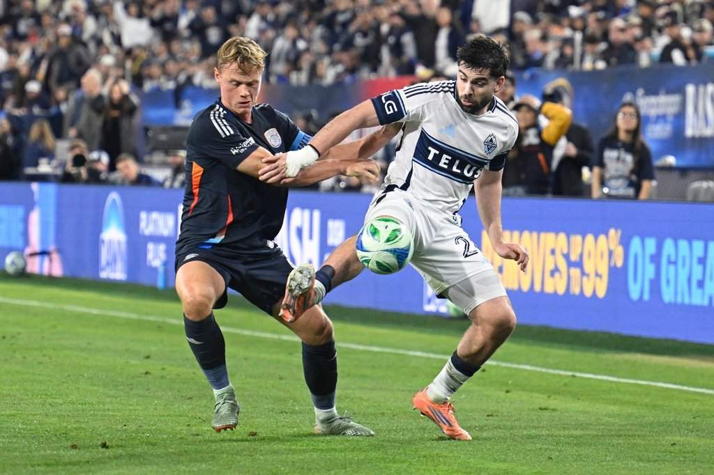 San Diego FC defender Jeppe Tverskov (6) fights for the ball with Vancouver Whitecaps forward Brian White (24) during the first half of an MLS Western Conference final soccer match Saturday, Nov. 29, 2025, in San Diego. (AP Photo/Denis Poroy).