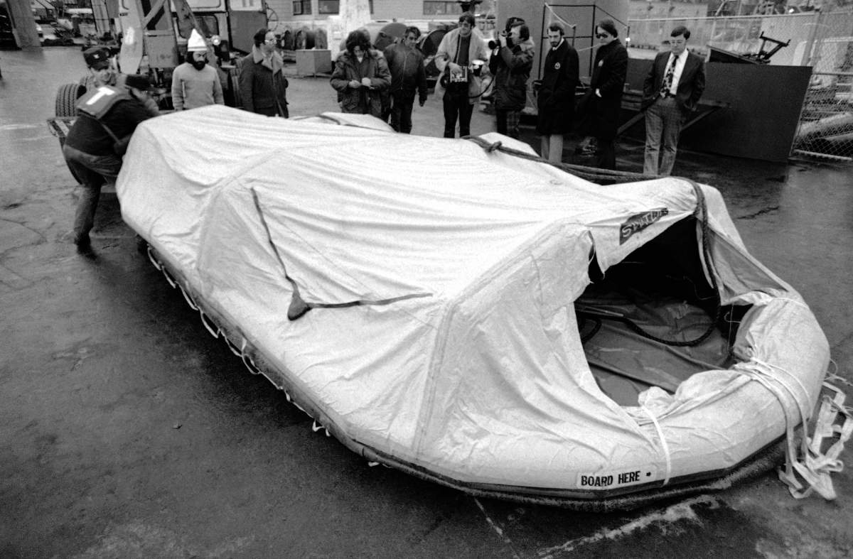 FILE – Two U.S. Coast Guardsmen move a life raft from the freighter Edmund Fitzgerald across the dock in Sault Ste. Marie, Mich. Nov. 11, 1975, after the raft was plucked from Whitefish Bay by the freighter Roger Blough, a ship assisting in the search for the missing Edmund Fitzgerald, which sunk on Nov. 10, 1975, in Lake Superior. (AP photo/JCH, file)