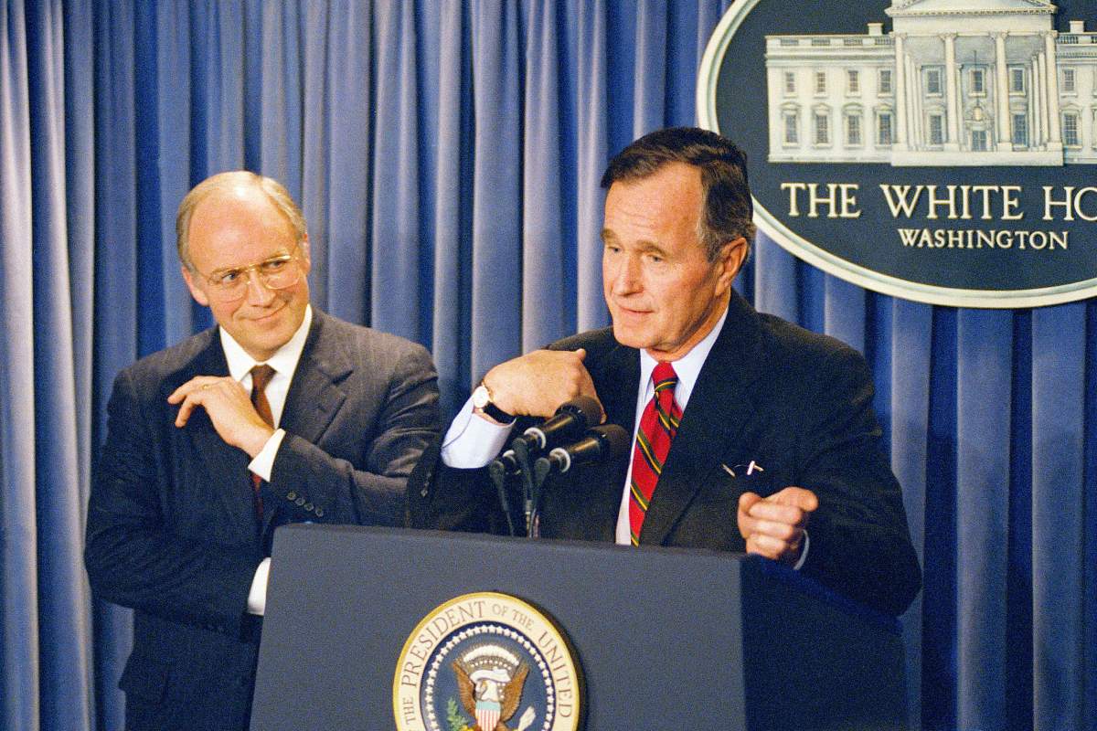 President George H.W. Bush gestures during a news conference at the White House on Friday, March 10, 1989, where he announced his selection of Rep. Richard Cheney, R-Wyo., left, to become Defense Secretary replacing his last choice of John Tower, whose nomination was turned down by the senate Thursday.