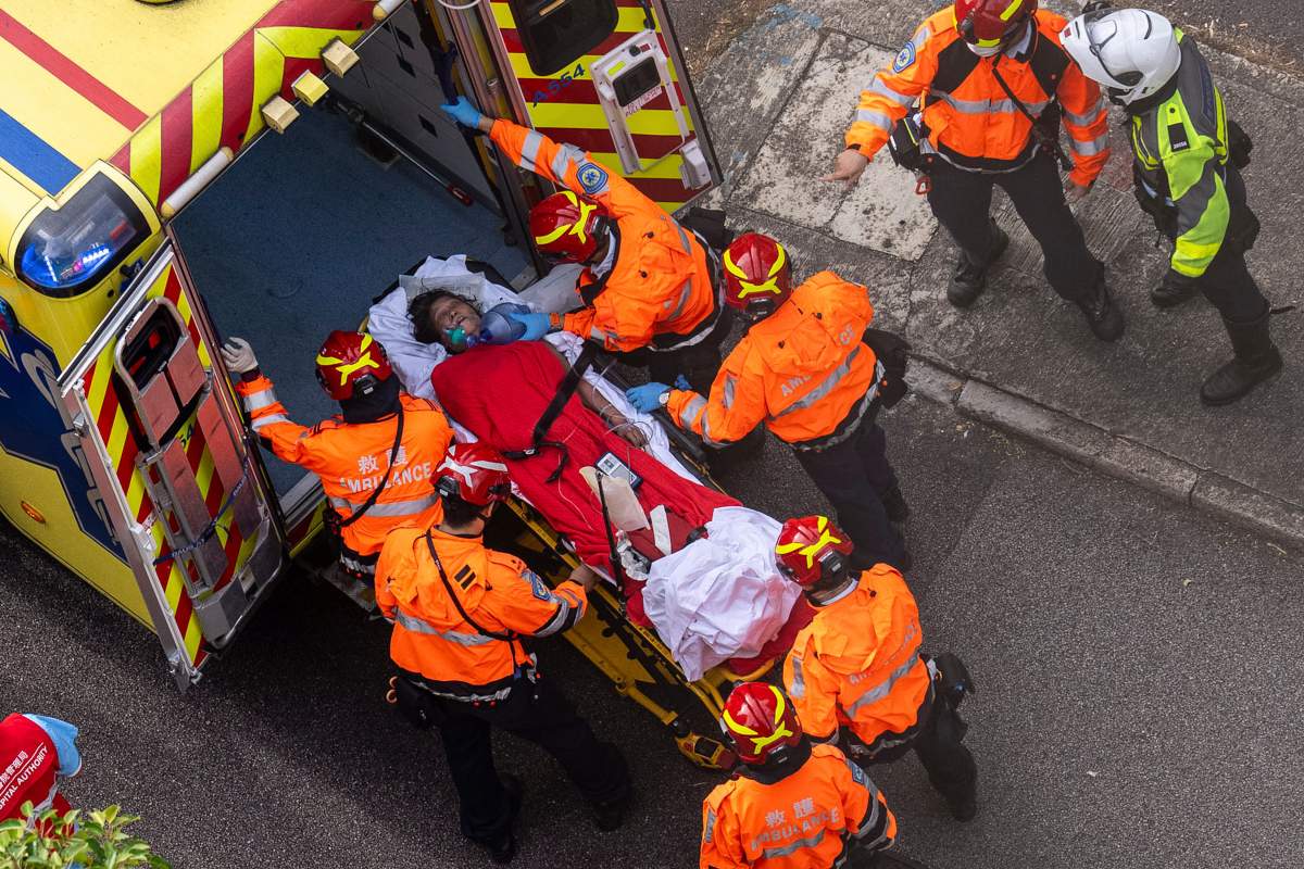 Health workers evacuate a woman from a fire which broke out at Wang Fuk Court, a residential estate in the Tai Po district of Hong Kong’s New Territories, Thursday, Nov. 27, 2025.