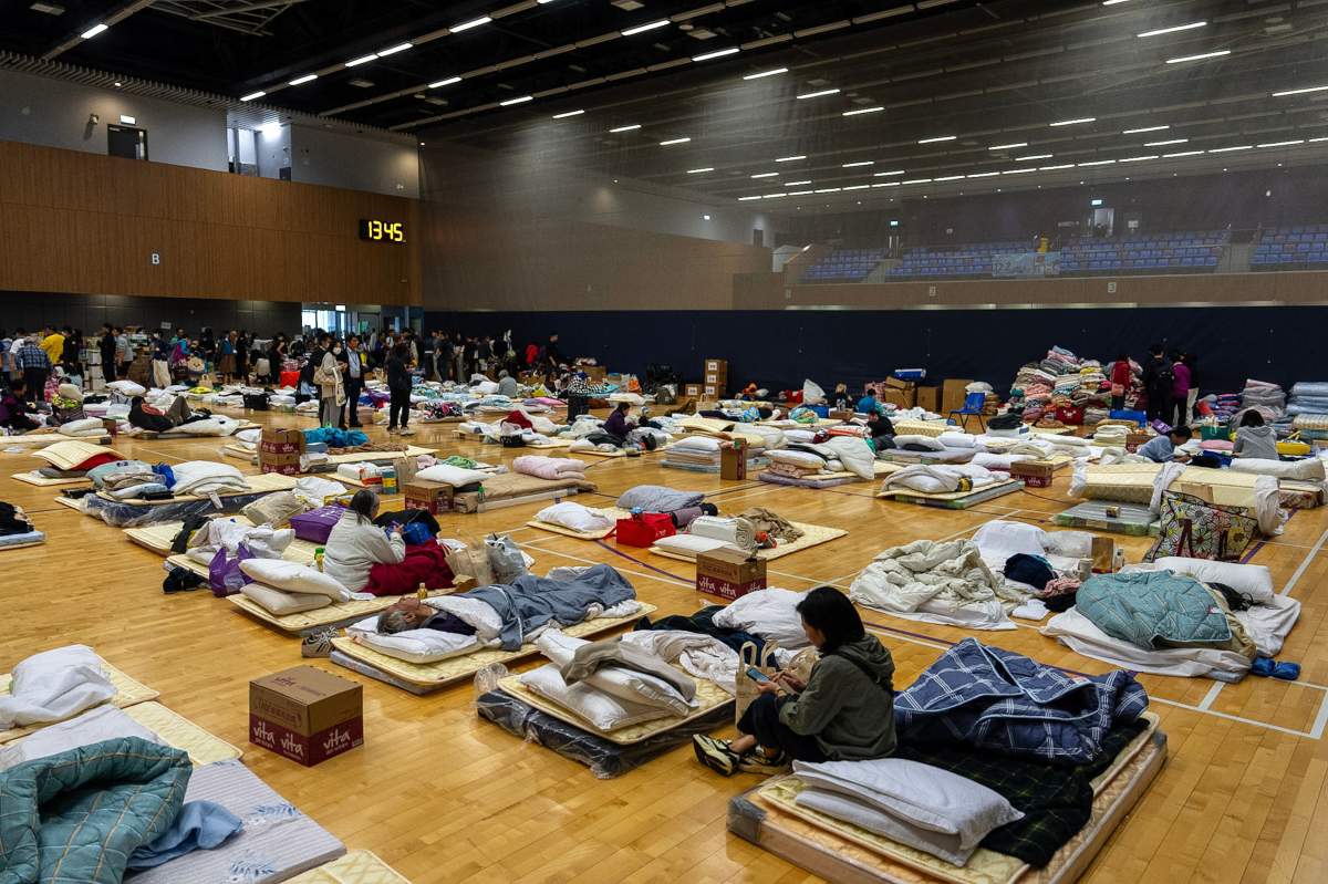 Residents rest at a temporary shelter near the fire scene at Wang Fuk Court, a residential estate in the Tai Po district of Hong Kong's New Territories, Thursday, Nov. 27, 2025.
