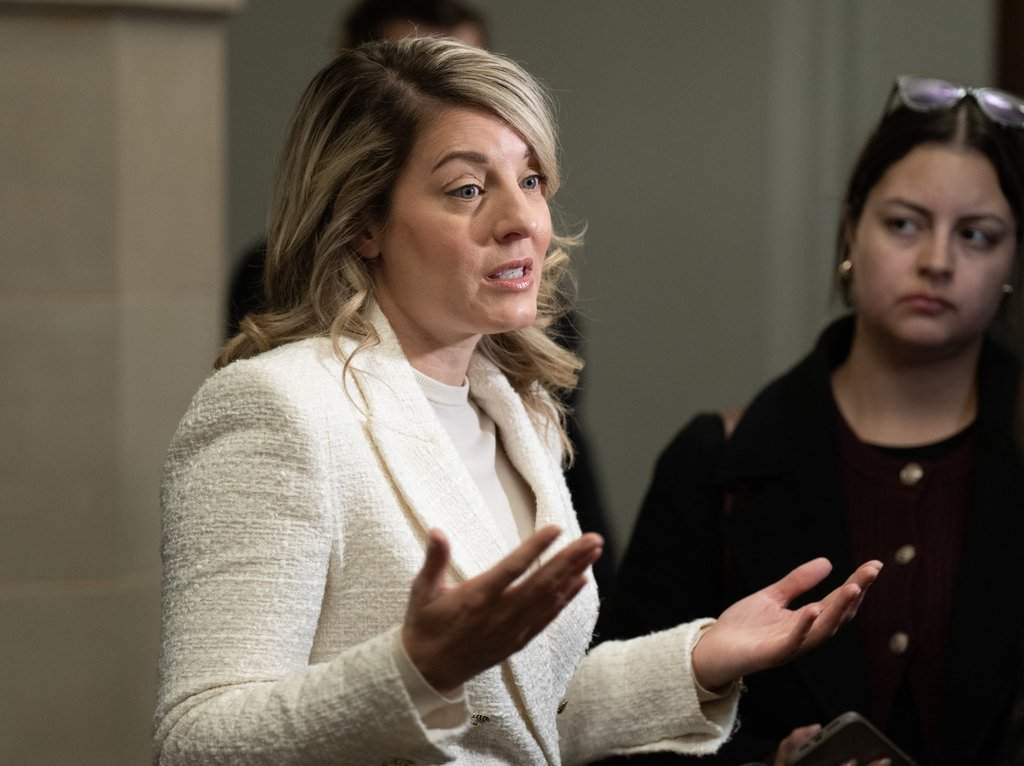 Industry Minister Melanie Joly speaks with reporters as she makes her way to a cabinet meeting on Parliament Hill, in Ottawa, Tuesday, Nov. 18, 2025.
