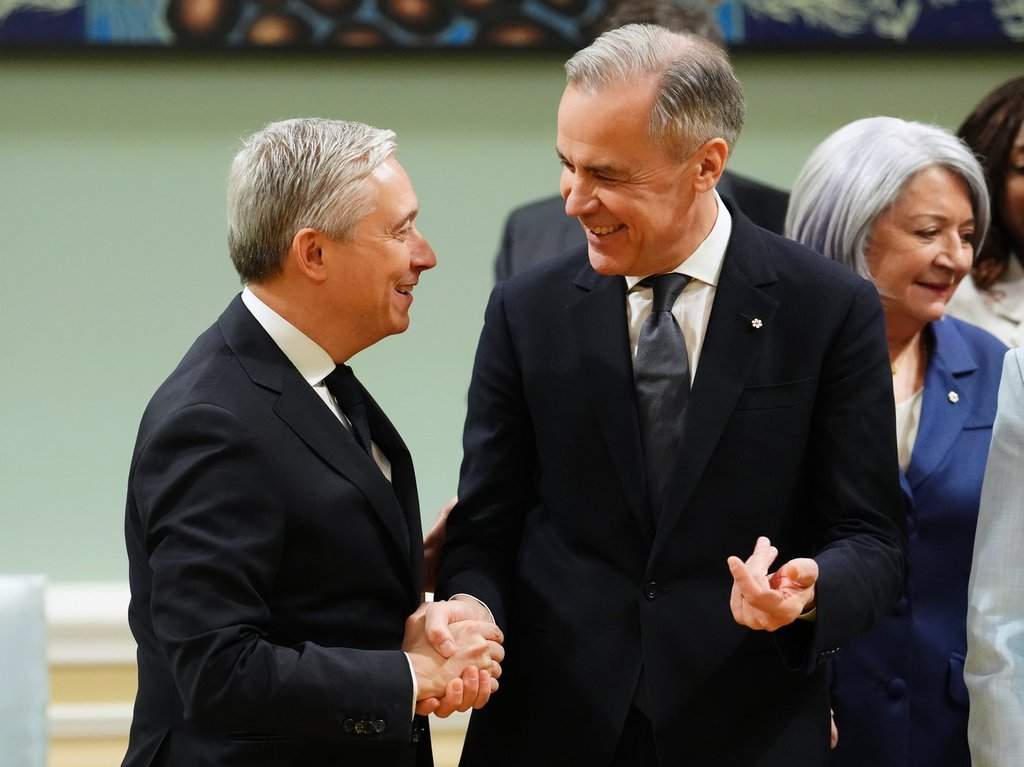 Prime Minister Mark Carney, right, shakes hands with Finance Minister Francois Philippe-Champagne at a ceremony at Rideau Hall in Ottawa on Friday, March 14, 2025.