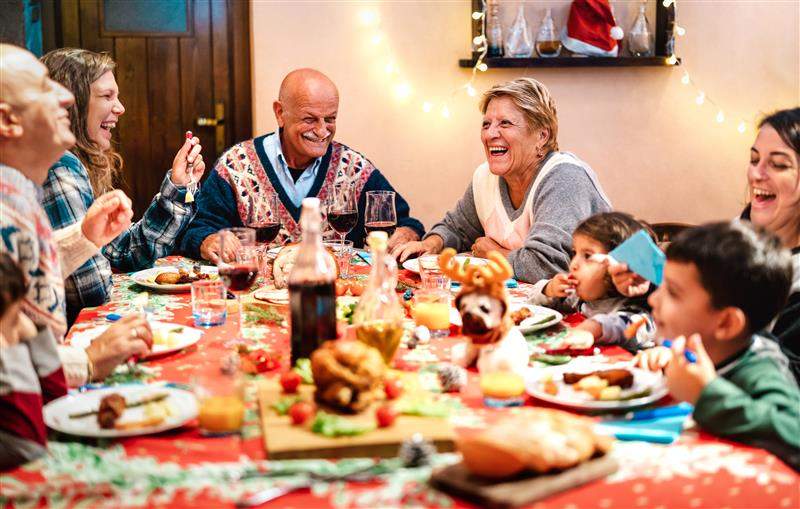 A multi-generation family having fun at a Christmas dinner event.