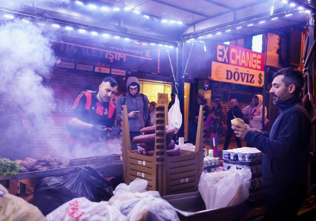 A file photo of street vendors sell food at a busy corner in Istanbul as protests carry on nearby, March 25, 2025.