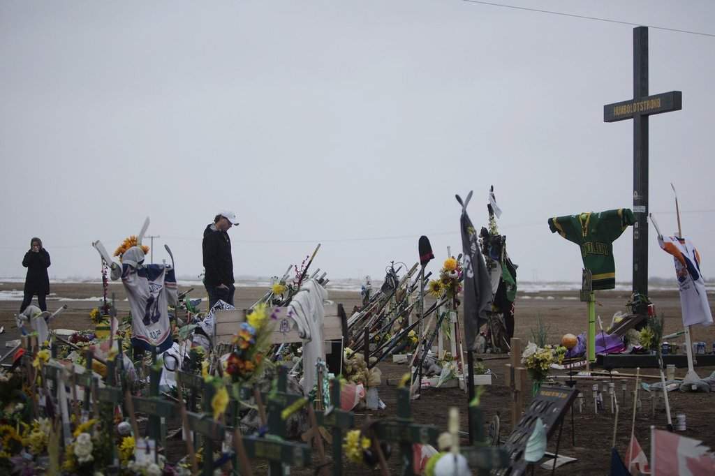 Mourners visit a memorial for the victims of the Humboldt Broncos bus crash on the corner of highway 35 and highway 335 near Codette, Sask. on Saturday, April, 6, 2019. 
