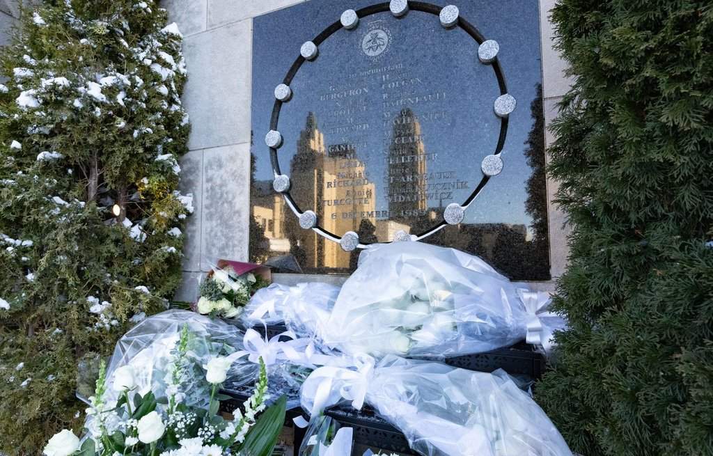 Flowers lay at a memorial for the victims of the 1989 École Polytechnique mass shooting, in Montreal, Friday, Dec. 6, 2024. Dec. 6 marks the anniversary of the anti-feminist massacre, which left 14 women dead and 13 others injured. THE CANADIAN PRESS/Christinne Muschi.