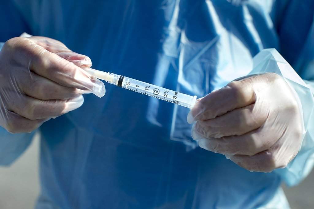 Doctor holding a needle and syringe