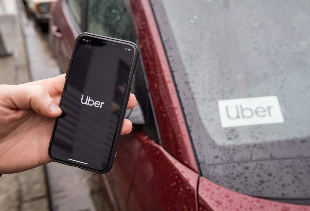 The Uber app is seen on an iPhone near a driver's vehicle in Vancouver, Friday, Jan. 24, 2020. THE CANADIAN PRESS/Darryl Dyck.