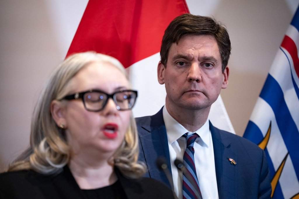 B.C. Premier David Eby, right, listens as B.C. Public Safety Minister Nina Krieger speaks during an announcement for new funding to support victims of crime, in Surrey, B.C. on Friday, November 28, 2025. 