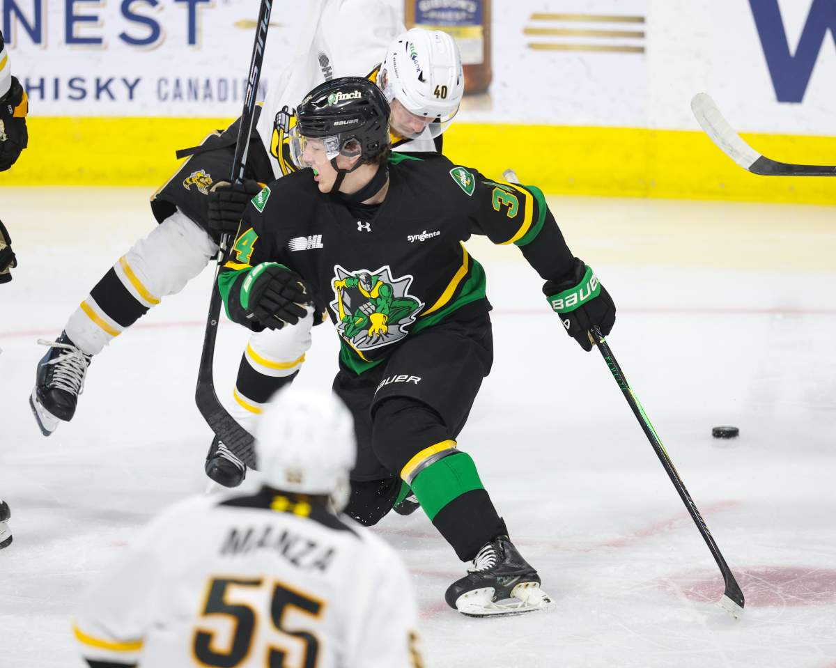 Chen Bidgood of the London Knights lays a body check in a game against the Sarnia Sting.
