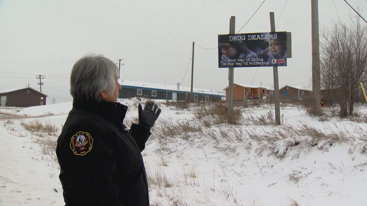 Kobliski stands near a billboard she installed that highlights the impact drug dealers are having on young people in the community. She says the sign had previously been torn down before they relocated it.