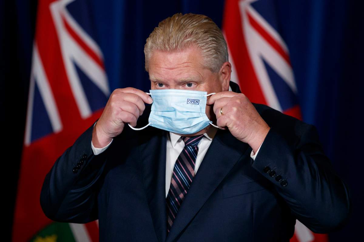 Ontario Premier Doug Ford puts his mask back on after speaking during a press conference at Queens Park in Toronto on Dec. 15, 2021.