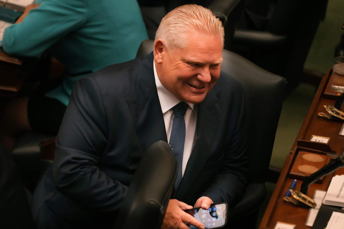 Ontario Premier Doug Ford uses his cell phone as he attends question period at the Queen's Park Legislature in Toronto on Wednesday October 25, 2023. 