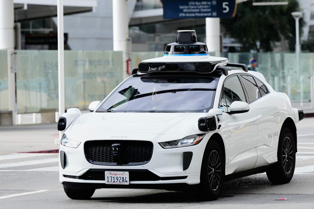 A passenger inside a Waymo vehicle looks out of the window while leaving the San Jose Mineta International Airport, Wednesday, Nov. 12, 2025, in San Jose, Calif.