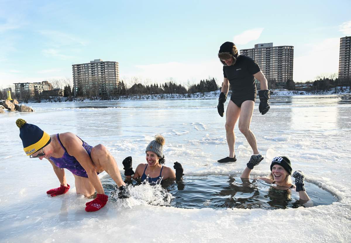 People take a polar plunge in the St. Lawrence River in Montreal, Wednesday, Dec. 31, 2025.