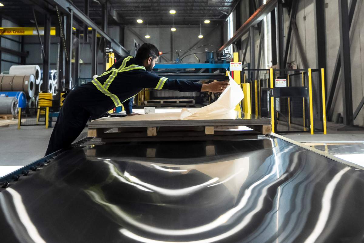 Workers inspect sheets of stainless steel after being pressed from coils, at Magna Stainless and Aluminum in Montreal on Thursday, Sept. 18, 2025.