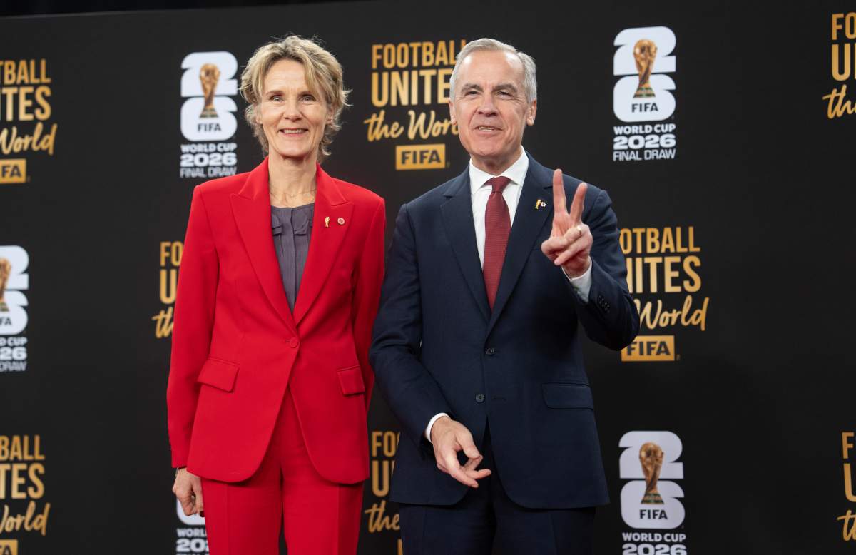 Prime Minister Mark Carney and his wife Diana Fox Carney pose for photographers as he arrives for the FIFA World Cup draw at the Kennedy Center, in Washington, Friday, Dec. 5, 2025.