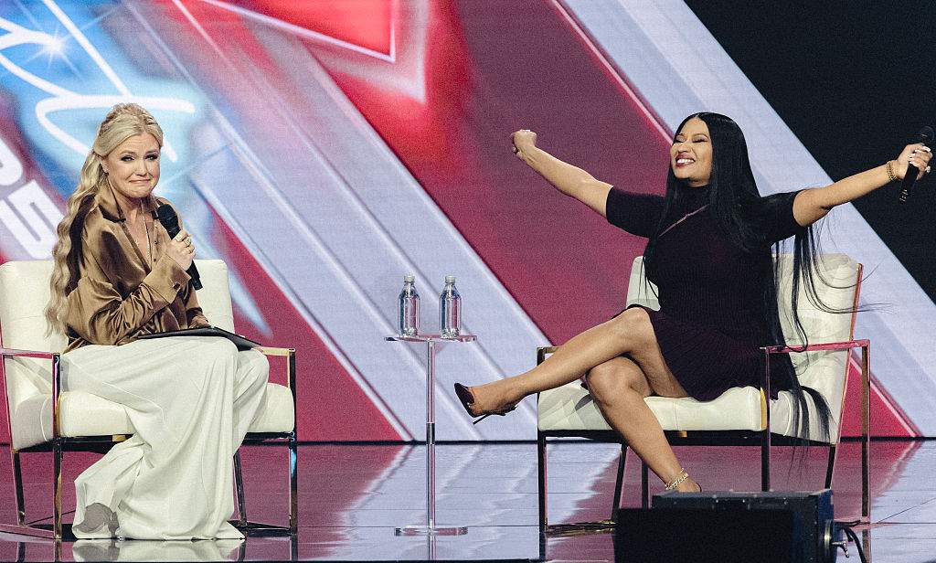 CEO and Chair of the Board of Turning Point USA Erika Kirk (L) speaks with US rapper Nicki Minaj during Turning Point's annual AmericaFest conference in Phoenix, Arizona on December 21, 2025.
