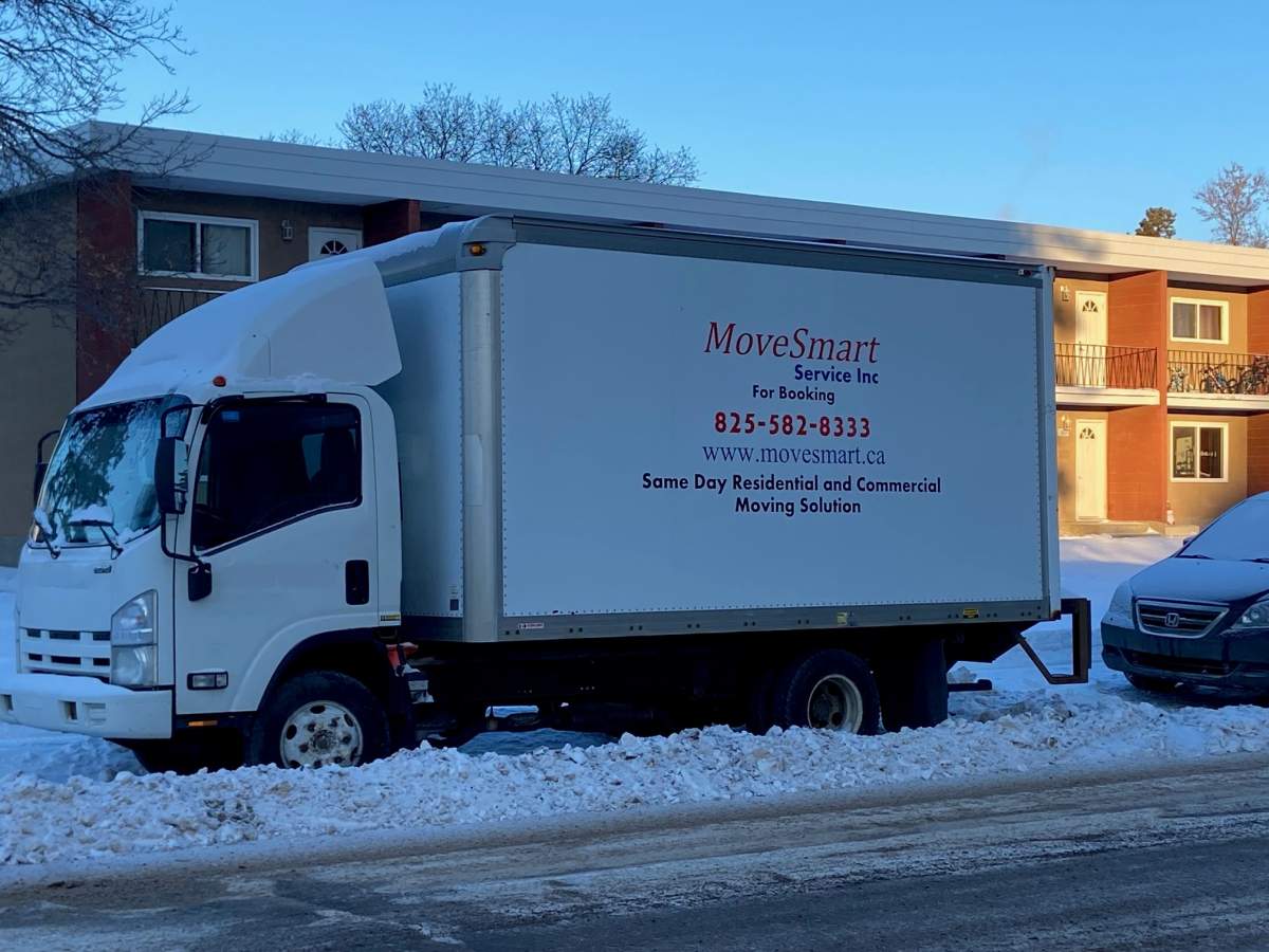 A vehicle that did not move off an Edmonton street and had a windrow plowed around it during a seasonal parking ban in December 2025.