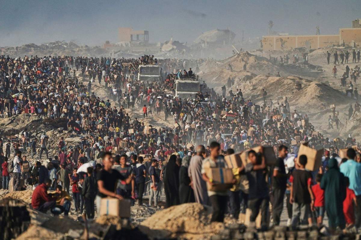 FILE - People carry sacks and boxes of food and humanitarian aid that was unloaded from a World Food Program convoy that had been heading to Gaza City in the northern Gaza Strip, June 16, 2025. (AP Photo/Jehad Alshrafi, File).