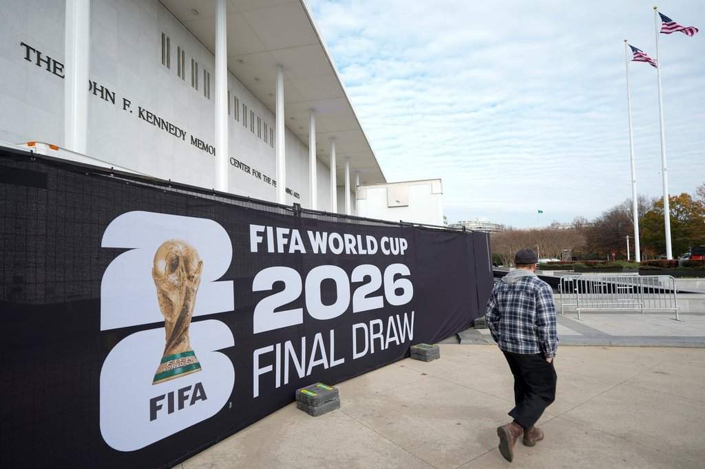 A man walks past signage prior to the final draw for the 2026 soccer World Cup at the Kennedy Center in Washington, Thursday, Dec. 4, 2025. (AP Photo/Chris Carlson).