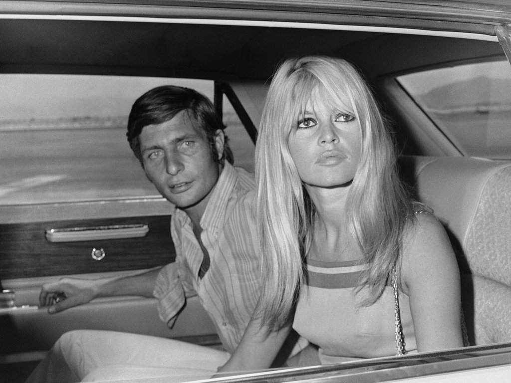 FILE – French film actress Brigitte Bardot and her husband Gunter Sachs pose just before boarding a chartered airplane on their honeymoon in Las Vegas on July 14, 1966.