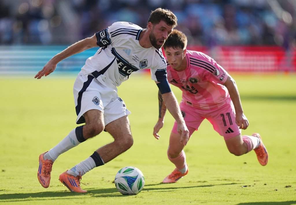 Vancouver Whitecaps' Thomas Muller (13) protects the ball from Inter Miami's Baltasar Rodriguez (11) during the first half of the MLS Cup final soccer match, in Fort Lauderdale, Fla., on Saturday, December 6, 2025. THE CANADIAN PRESS/Darryl Dyck.