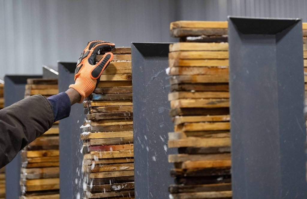 Workers stack and sort softwood lumber at Groupe Crete, a sawmill in Mont-Blanc, Que., Monday, Jan. 20, 2025.