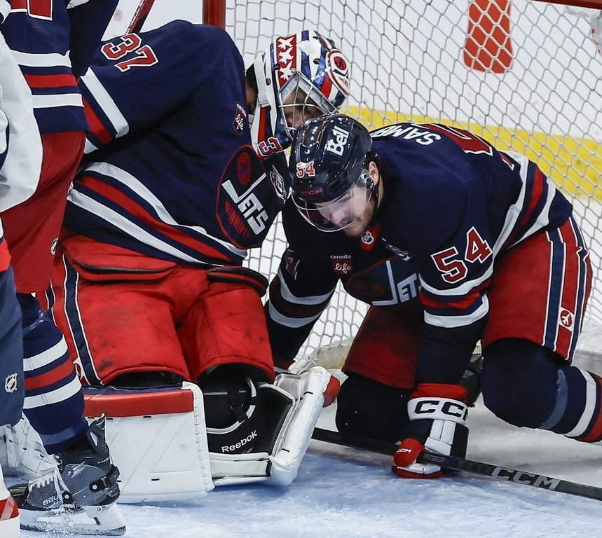 Winnipeg Jets goaltender Connor Hellebuyck (37) reaches back for the rebound off Washington Capitals' Tom Wilson's (not shown) shot during third period NHL action in Winnipeg on Saturday, December 13, 2025.