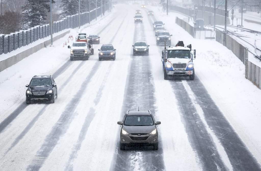 Traffic creeps along snow-covered roads in Calgary on Monday, Nov. 7, 2022. THE CANADIAN PRESS/Jeff McIntosh.