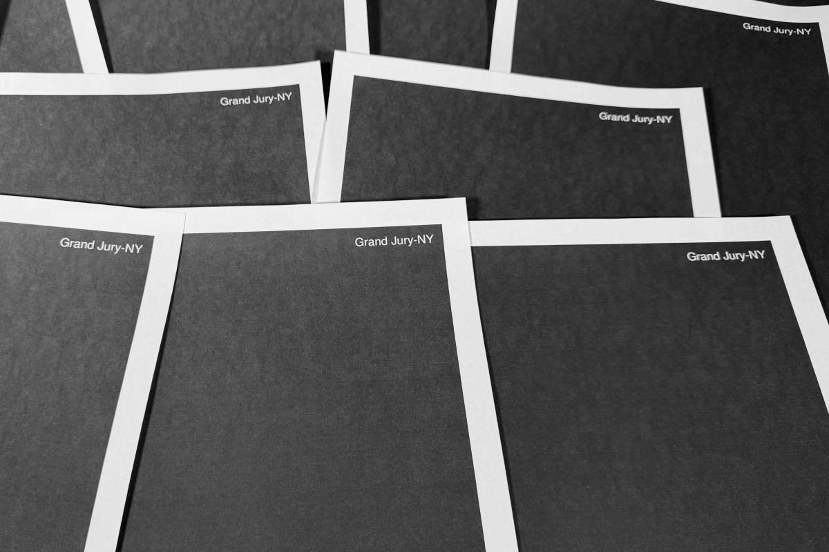 Pages from a totally redacted New York grand jury file into Jeffrey Epstein and Ghislaine Maxwell, released by the U.S. Justice Department, is photographed Friday, Dec. 19, 2025, in Washington.