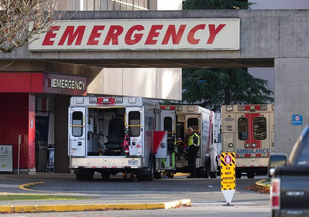 A paramedic is seen outside ambulances parked at the entrance to the emergency department at Richmond General Hospital, in Richmond, B.C., Sunday, Nov. 27, 2022. 