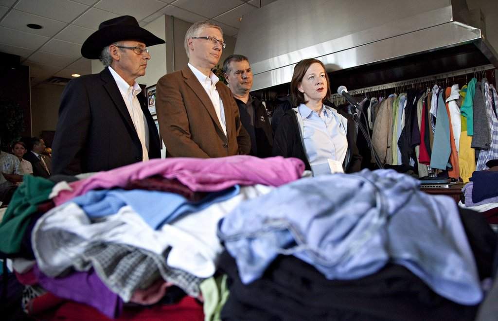 Former Alberta agriculture and justice minister Verlyn Olson, second left, and former Alberta premier Alison Redford speak with media at the Cargill meat processing plant north of High River, Alberta on Thursday June 27, 2013. 
